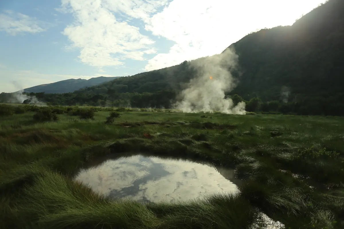 Steaming Sempaya hot spring pool reflecting the sky in Semuliki National Park